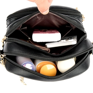 Black litchi leather crossbody bag with triple zipper layers and gold hardware