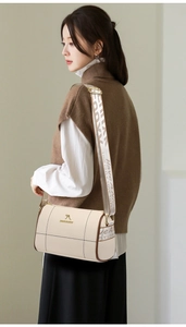 Détail du sac polochon en cuir souple avec logo kangourou doré et large bandoulière tissu