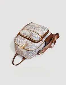 Detailed view of Oriental wave jacquard fabric and brown leather straps on a backpack