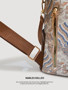 Detail of embroidered cloud patterns and golden hardware on the retro backpack