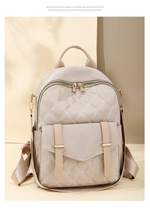 Detail des beige gesteppten Rucksacks mit Rautenmuster und vorderer Klappentasche