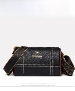 Vue de face du sac cylindrique noir en cuir grainé avec logo kangourou doré brillant