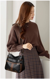 Close-up of multi-layer zipper pockets on black woven leather crossbody bag for women