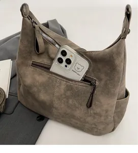 Detail view of large brown faux suede tote bag with zipper pocket and spacious interior