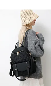 Moderner schwarzer Stepprucksack mit Goldreißverschlüssen am Modell in Freizeitkleidung