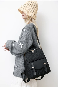 Seitenansicht eines schwarzen gesteppten Nylon-Rucksacks mit goldenen Metallschnallen