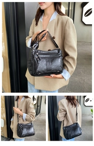 Detail view of large capacity black soft leather crossbody bag with multiple zip pockets