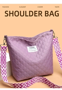 Detail of purple quilted nylon shoulder bag with geometric pattern wide strap and white tag