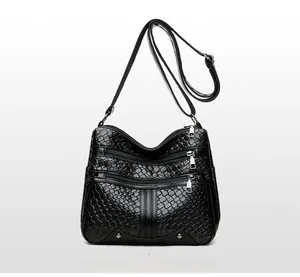Detailed front view of black woven crossbody bag with triple silver zippers and soft leather
