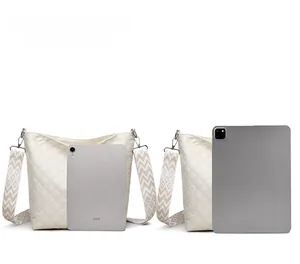 Detailed size comparison of quilted crossbody bag against iPad and iPad mini devices