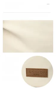 Macro shot of durable off-white canvas fabric and brown leather brand logo patch