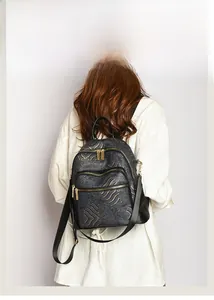 Detail of black backpack with gold wave jacquard texture and multiple zip layers