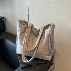 Light grey padded tote bag in crinkled nylon fabric with woven zipper detail
