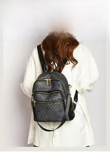 Detail of Chinese style backpack featuring golden wave patterns and zipper pockets
