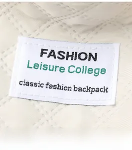 Detail of quilted diamond pattern and rectangular fabric label on beige shoulder bag
