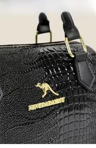 Détail du sac cylindrique noir brillant motif crocodile avec logo kangourou doré