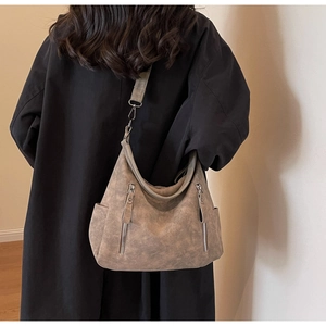 Close-up of retro taupe crossbody bag with double zippers and silver hardware
