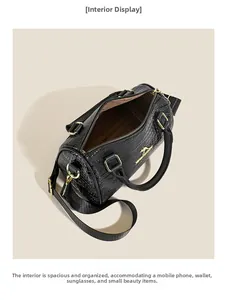 Vue interne du sac cylindre noir à motif crocodile montrant la doublure et l'espace