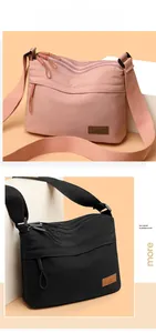 Detail of waterproof nylon crossbody bags in pink and black with multi-zipper layers