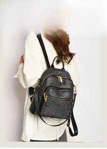 Detailed view of women's vintage black leather backpack with gold cloud pattern details
