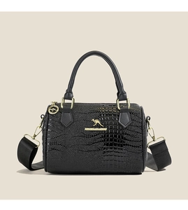 Détail de la texture cuir croco et logo kangourou doré sur un sac à main noir élégant