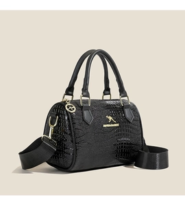 Détail du sac cylindre noir à texture crocodile avec logo et ferrures dorés brillants