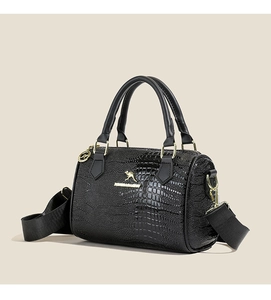 Gros plan du sac Boston noir à motif crocodile avec logo kangourou et finitions dorées