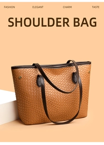 Detail of brown woven shoulder bag with dark leather handles and gold rivet accents