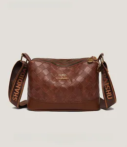 Dettaglio borsa trapuntata marrone in pelle PU con tre zip e tracolla ampia e hardware oro