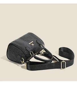 Détail d'un sac à main noir à relief crocodile avec fermeture éclair dorée de luxe