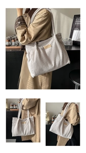 Detail of white corduroy tote bag with leather logo patch and vertical ribbed texture
