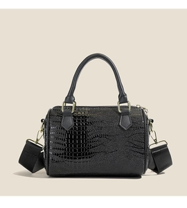 Détails du sac cylindre noir à texture crocodile avec boucles en métal doré et bandoulière