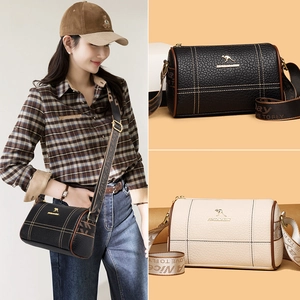 Sac cylindre en cuir souple noir et beige avec large bandoulière à logo imprimé