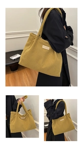 Detail of large corduroy tote bag in mustard yellow with fashion label and shoulder straps