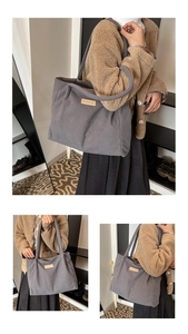 Detail of grey corduroy tote bag showing vertical ribbed texture and leather logo patch