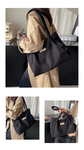 Detailed texture of black corduroy tote bag featuring a premium leather fashion label