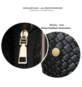 Close-up of golden zipper and safety lock on black woven texture tote shoulder bag
