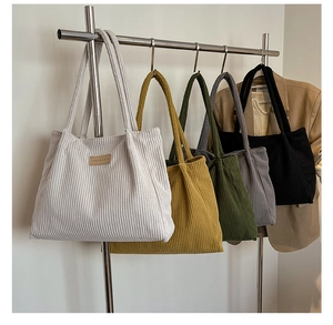 Detail showing five colors of large corduroy tote bags with leather fashion patches