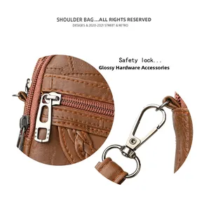 Detail of brown litchi grain leather bag showing shiny hardware and safety lock closure