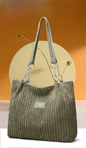 Detailed texture of olive green corduroy tote bag with silver chain strap and logo
