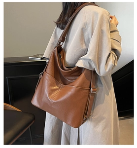 Detail einer braunen Leder-Hobo-Tasche mit Lychee-Muster und Reißverschlüssen