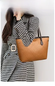 Detail of brown tote bag featuring fine woven texture and slim dark leather handles