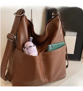 Detail der braunen Ledertasche mit zwei großen Fronttaschen für viel Stauraum