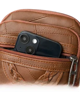 Macro view of dark brown leather crossbody bag with a front pocket holding a smartphone