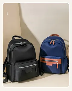 Detail of high-density nylon backpacks in black and navy with leather trim and zippers