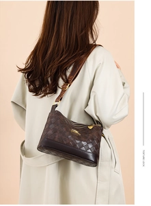 Dettaglio borsa in pelle trapuntata marrone scuro con logo dorato e tracolla jacquard