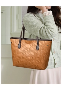 Close-up of woven leather texture and metal rivets on a brown vintage tote bag