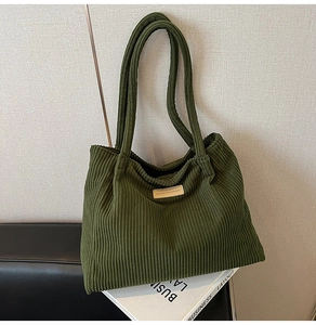 Detail of army green corduroy tote bag featuring a textured finish and fashion label