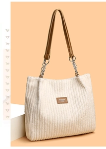 Macro view of cream corduroy fabric texture and leather brand label on tote bag