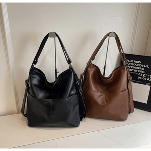 Makroaufnahme von minimalistischen schwarzen und braunen Leder-Tote-Bags mit Seitenriemen
